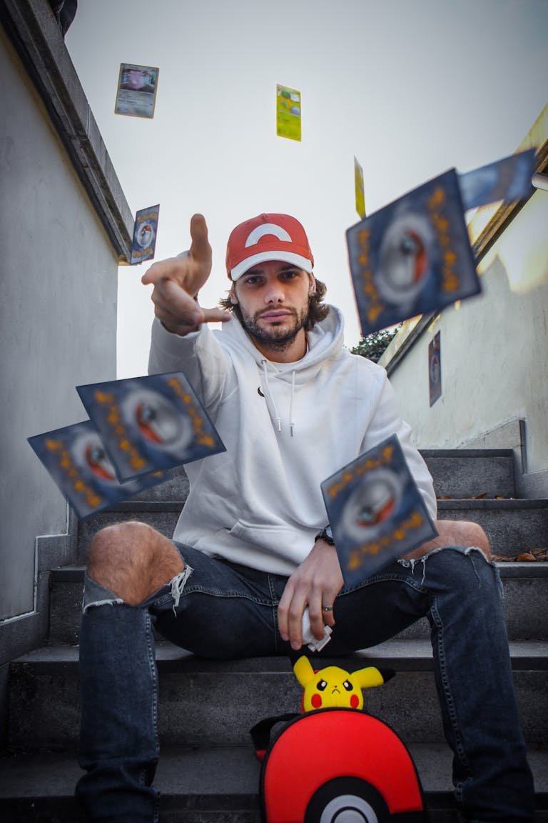 Man in Gray Hoodie Sweater Throwing Pokemon Cards